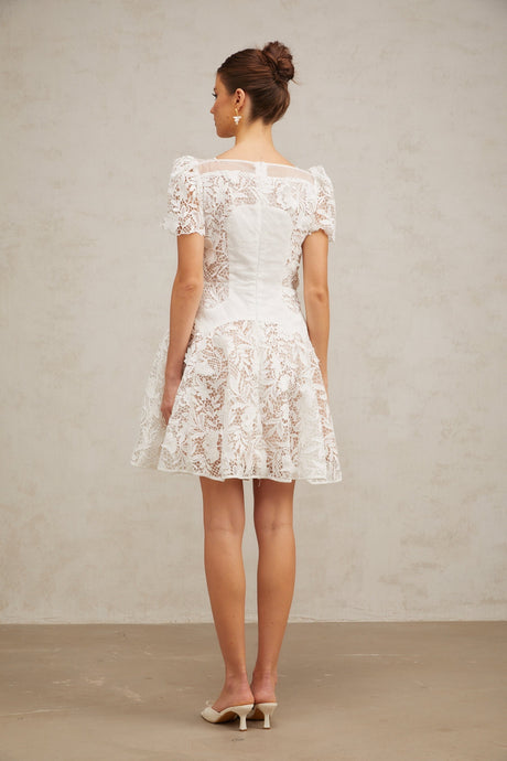 A white mini dress with floral lace pattern and puff sleeves featuring a romantic Josette design