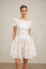 A white mini dress with floral lace pattern and puff sleeves in a romantic Josette style
