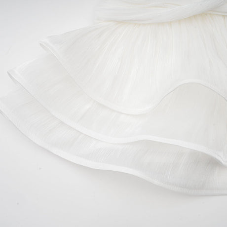 A white mini dress with full pleats and a cinched waist featuring a rosier design on a model against a plain background