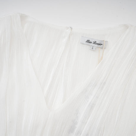 A white mini dress with full pleats and a cinched waist featuring a rosier design