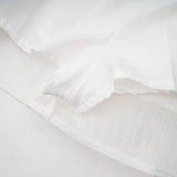 A white mini dress with full pleats and a cinched waist featuring a rosier design