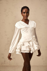 A white mini dress with full pleats and a cinched waist featuring a rosier design