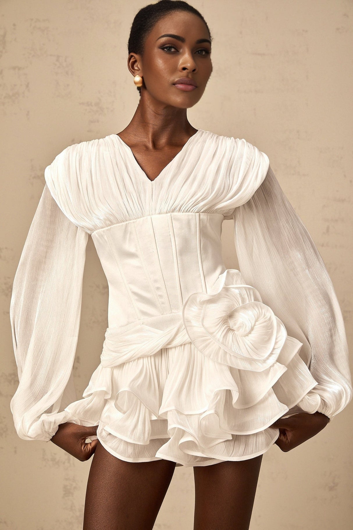 A white mini dress with full pleats and a cinched waist featuring a rosier style