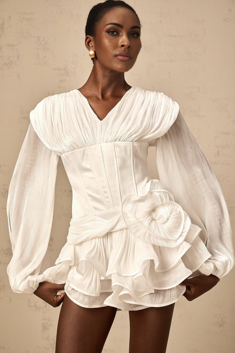 A white mini dress with full pleats and a cinched waist featuring a rosier style