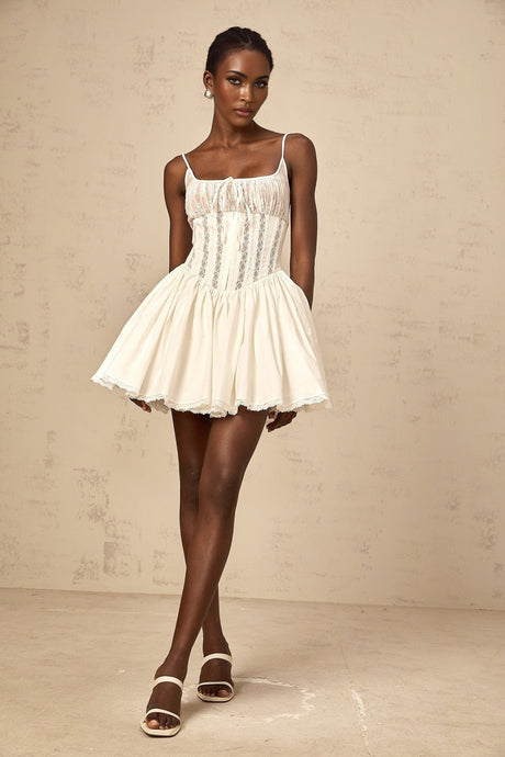 A white mini dress with lace details and a corsetstyle bodice featuring a fitted silhouette and short hemline