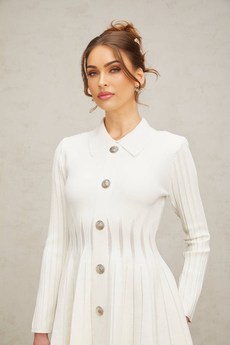 A white mini dress with pleated knit fabric featuring a fitted silhouette and short length named Emeline