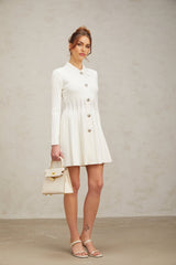 A white mini dress with pleated knit fabric featuring a fitted silhouette and short length named Emeline