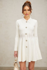 A white mini dress with pleated knit fabric featuring short sleeves and a fitted silhouette named Emeline