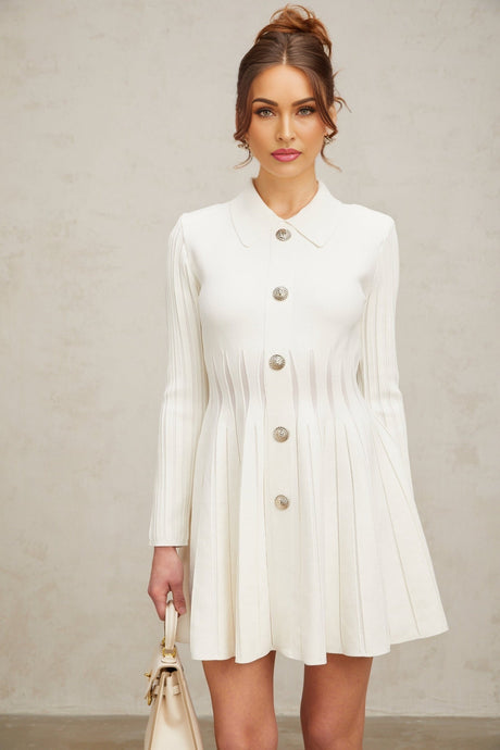 A white mini dress with pleated knit fabric featuring short sleeves and a fitted silhouette named Emeline