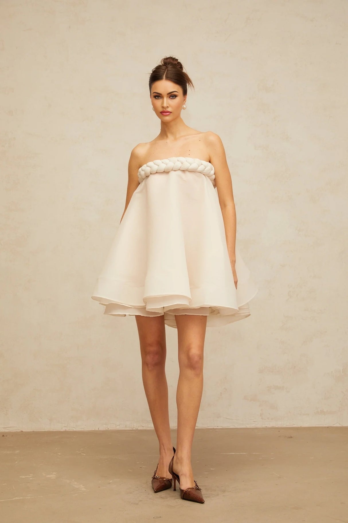 A white mini dress with puff sleeves and braided detailing named Violette