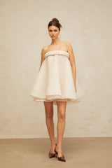 A white mini dress with puff sleeves and braided detailing named Violette