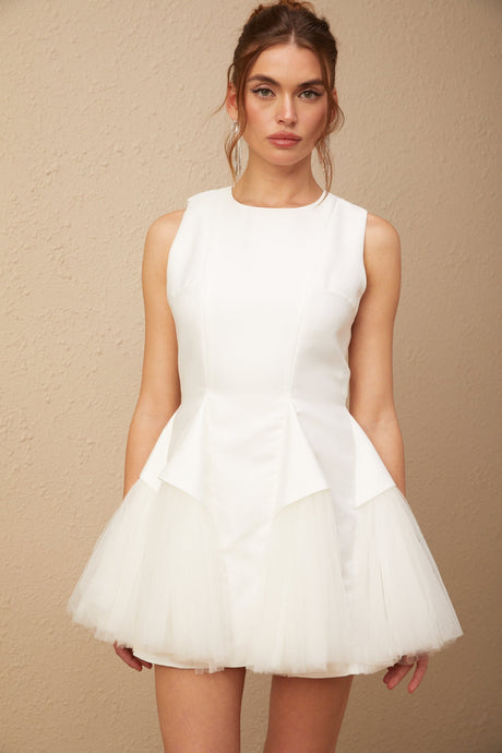 A white mini dress with puff sleeves and tulle paneling featuring a fitted bodice and flared skirt