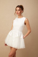 A white mini dress with puff sleeves and tulle panels featuring a fitted bodice and flared skirt