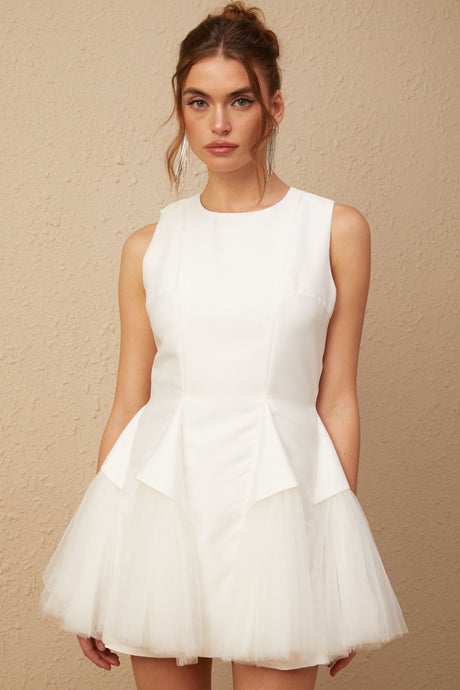 A white mini dress with puff sleeves and tulle panels featuring a fitted bodice and flared skirt