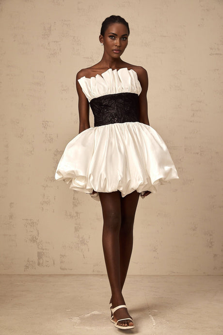 A white mini dress with puff sleeves featuring lace panelling and a satin finish
