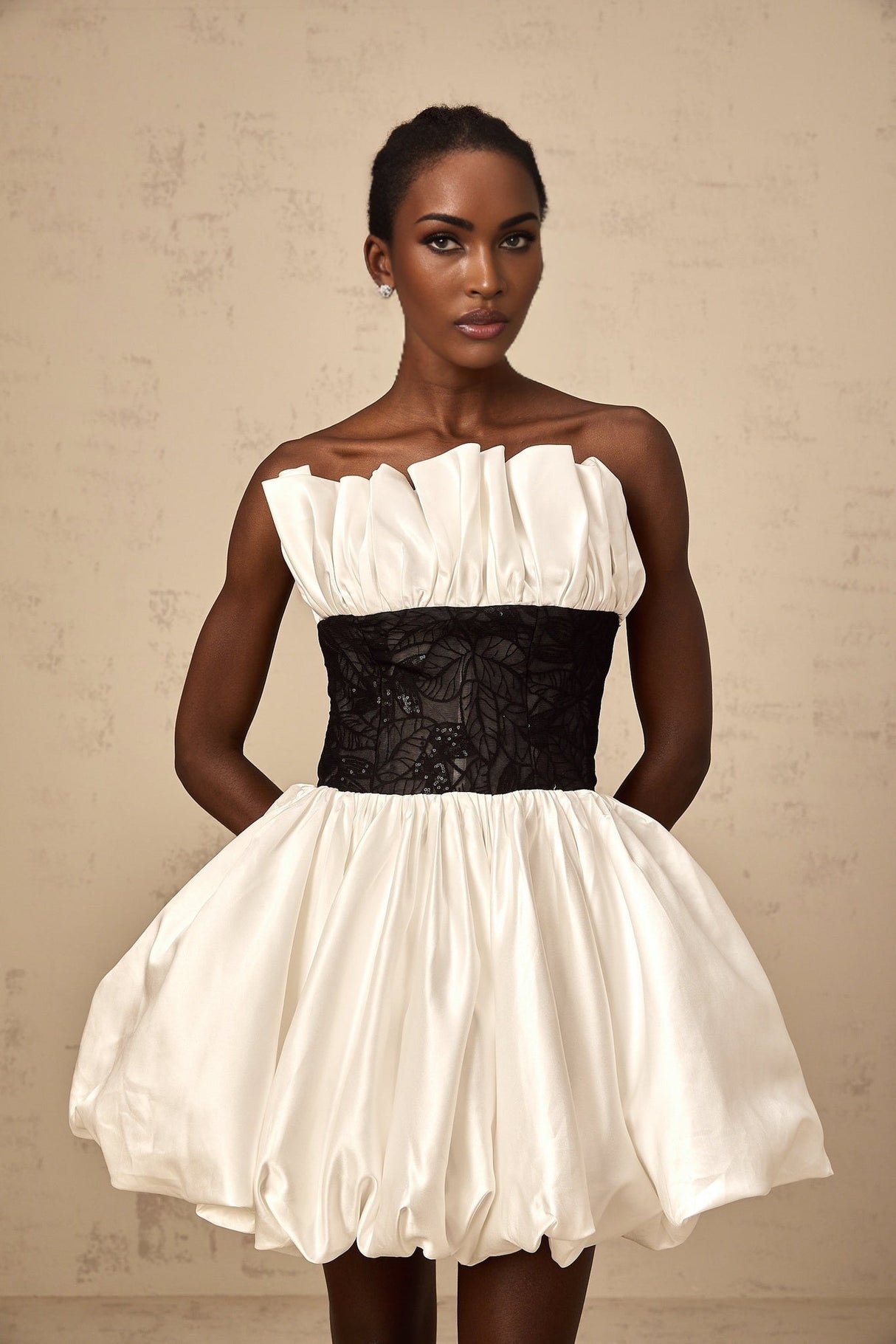 A white mini dress with puff sleeves featuring lace panels and a satin fabric