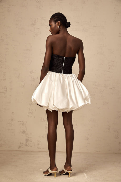 A white mini dress with puff sleeves featuring lace panels and a satin finish named Éliane