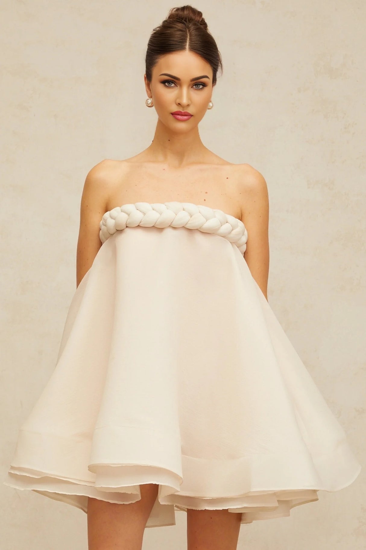 A white mini dress with puffed sleeves and braided detailing named Violette