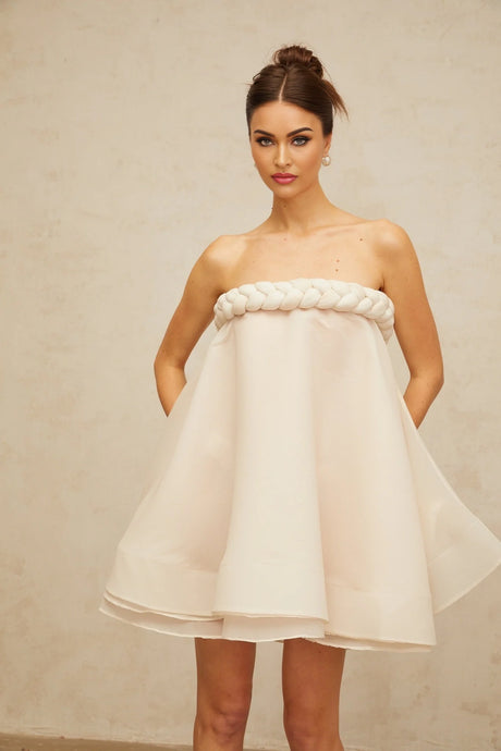 A white mini dress with puffed sleeves and braided detailing named Violette