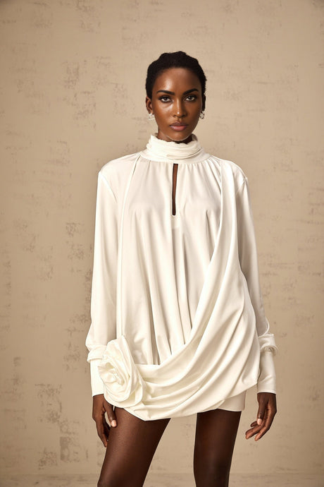 A white mini dress with ruched detailing and faux flower embellishments called the Maeva dress