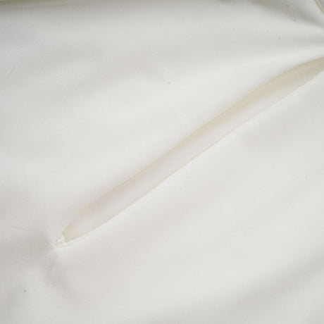 A white mini dress with ruched detailing and faux flower embellishments called the Maeva dress