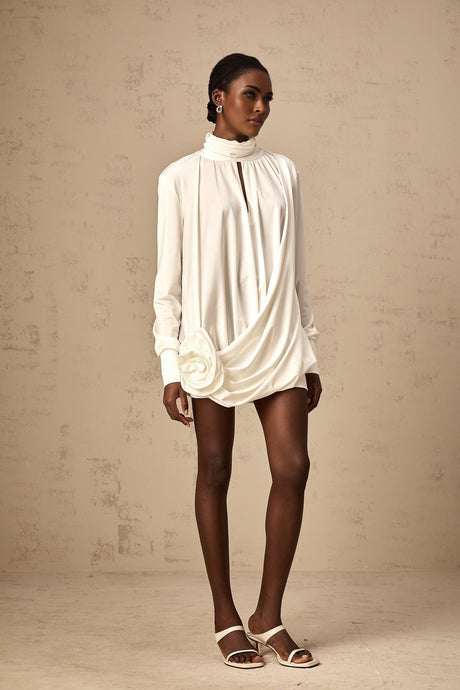 A white mini dress with ruched detailing and faux flower embellishments featuring a fitted silhouette and short length