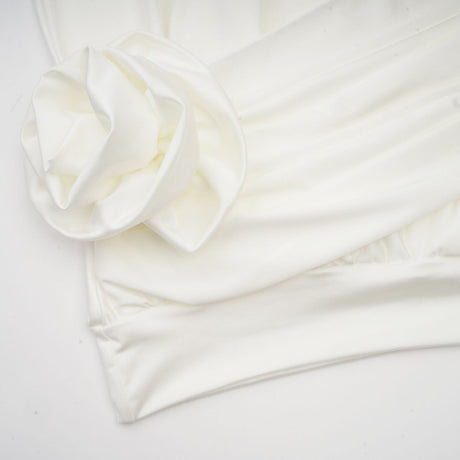 A white mini dress with ruched detailing and faux flower embellishments named Maeva