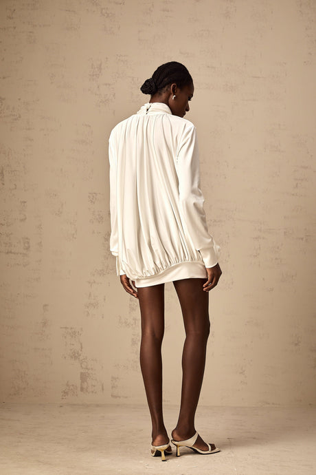A white mini dress with ruched details and faux flower embellishments named Maeva