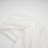 A white mini dress with ruched fabric and ribbon design details featuring a short hemline and fitted silhouette