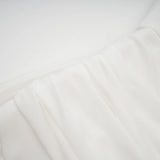 A white mini dress with ruched fabric and ribbon design details featuring a short hemline and fitted silhouette