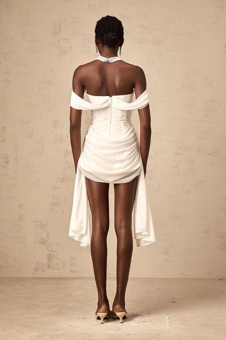 A white mini dress with ruched fabric and ribbon design details featuring a short hemline and formfitting silhouette