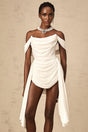 A white mini dress with ruched fabric featuring a ribbon design detail and a short hemline