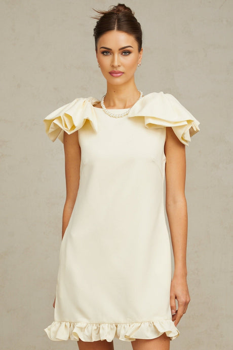 A white mini dress with ruffles and a bow detail named Constance