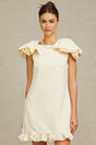 A white mini dress with ruffles and a bow detail named Constance