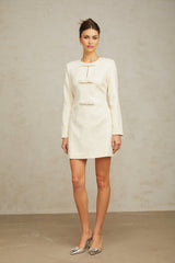 A white mini dress with sequin embellishments and tweed texture featuring a fitted silhouette and short hemline