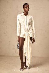 A white mini shirt dress with ruched detailing and ribbon accents named Daphne featuring a short length and buttonup design