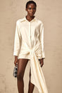 A white mini shirt dress with ruched detailing and ribbon accents named Daphne featuring a short length and feminine design