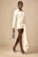 A white mini shirt dress with ruched detailing and ribbon accents named Daphne featuring a short length and fitted silhouette