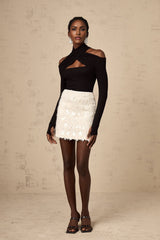 A white mini skirt adorned with shimmering sequins creating a glamorous and eyecatching look