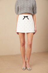 A white mini skirt with a bowknot detail and crystal embellishments named Gabrielle