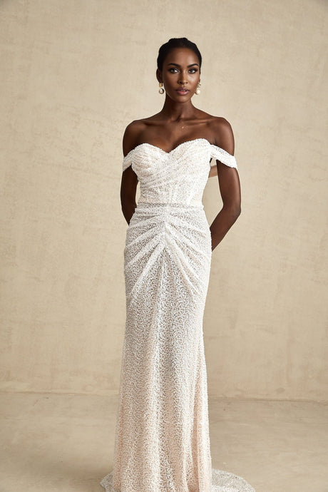 A white offshoulder maxi dress with embellishments named Margot worn by a model against a plain background