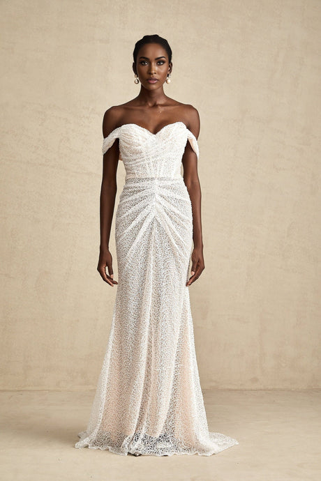 A white offshoulder maxi dress with embellishments worn by a model named Margot