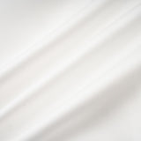 A white offshoulder maxi dress with panel detailing worn by a model standing against a plain background