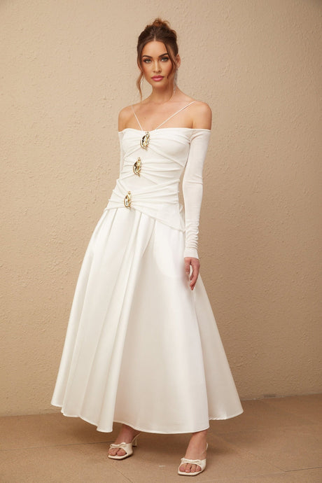 A white offshoulder maxi dress with panelled design featuring a fitted bodice and flowing skirt worn by a model against a plain background