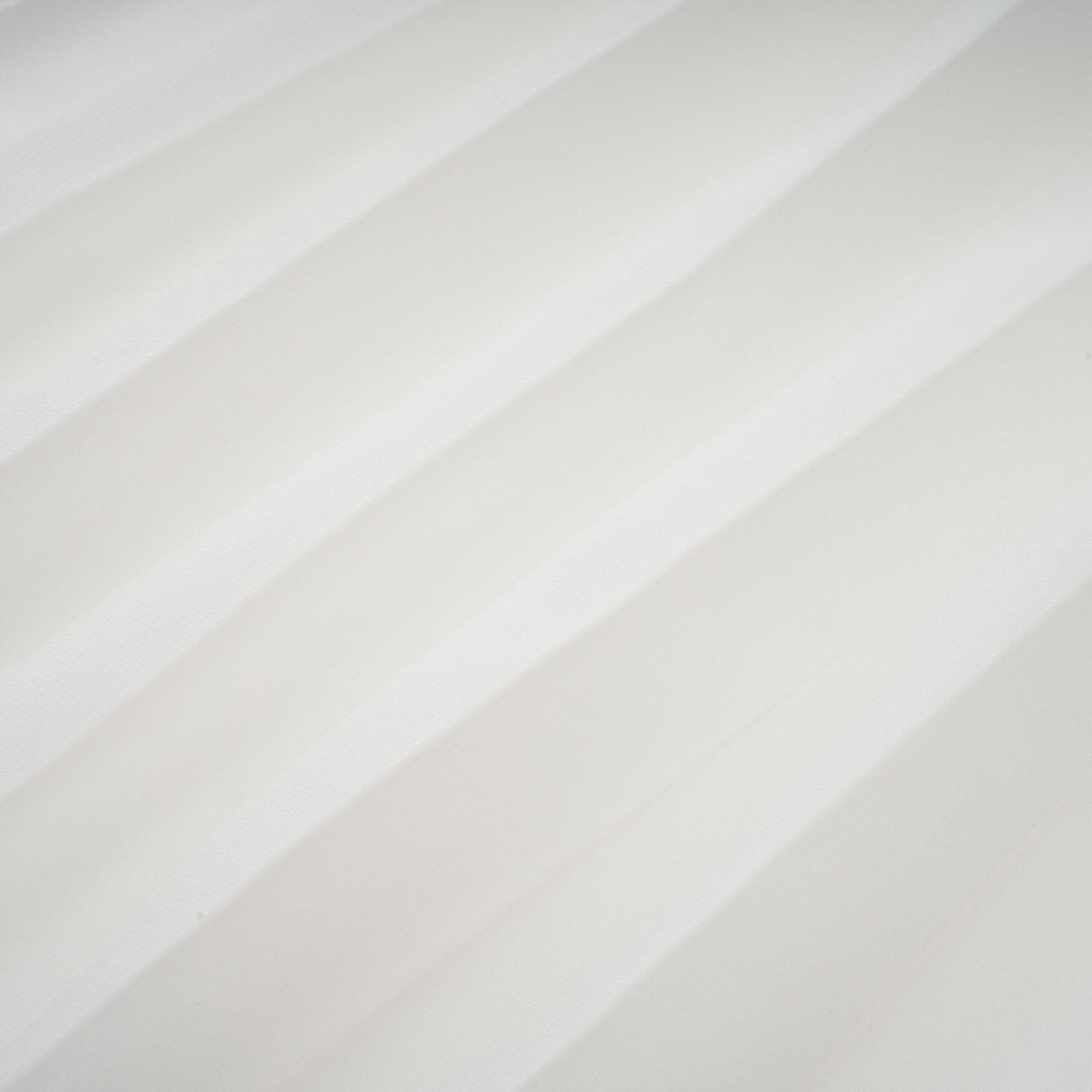 A white offshoulder maxi dress with pleated details and a flowing silhouette worn by a model named Vanessa