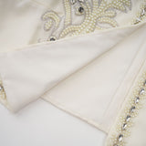 A white pleated jacket and dress set with embellishments featuring a matching design for a coordinated elegant look