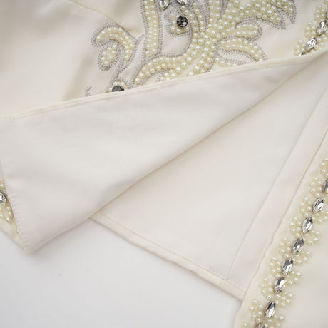 A white pleated jacket and dress set with embellishments featuring a matching design for a coordinated elegant look