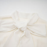 A white pleated jacket and dress set with embellishments featuring a matching design The jacket is worn over the dress creating an elegant coordinated outfit