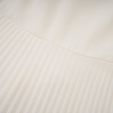 A white pleated jacket and dress set with embellishments The jacket features decorative details and the dress has a matching pleated design Both pieces are shown together as a coordinated outfit