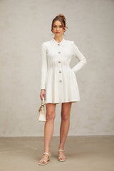 A white pleated knit mini dress named Emeline shown on a model or mannequin against a plain background
